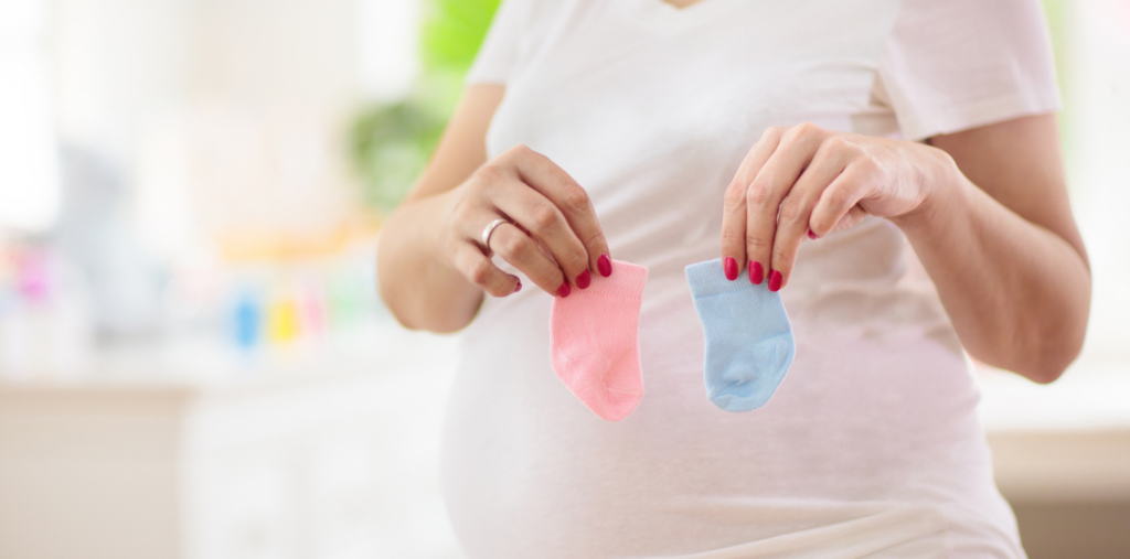 woman holding up baby girl and baby boy socks