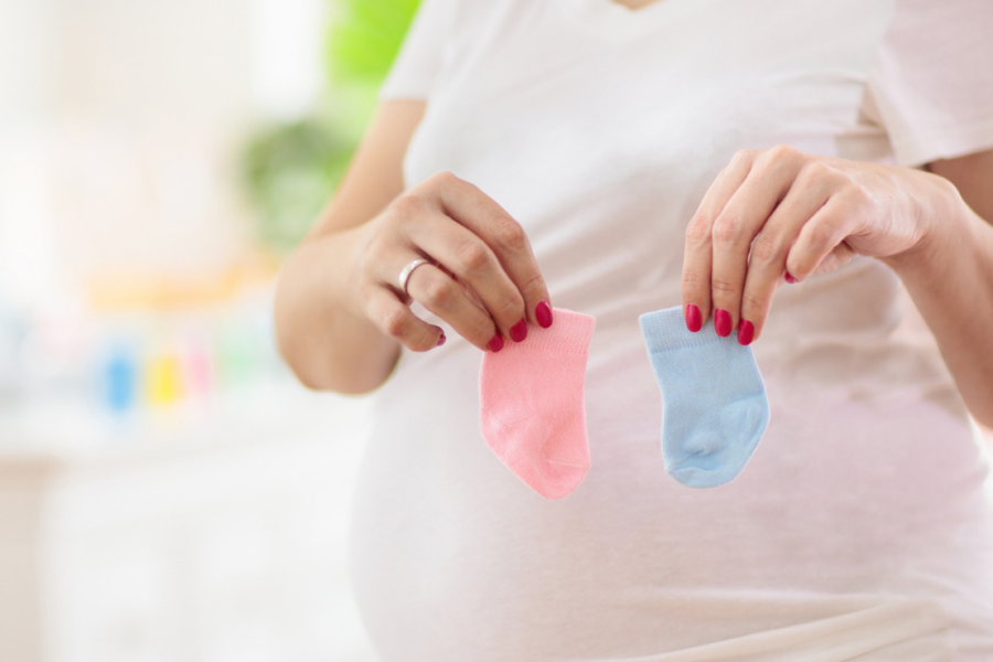 woman holding up baby girl and baby boy socks
